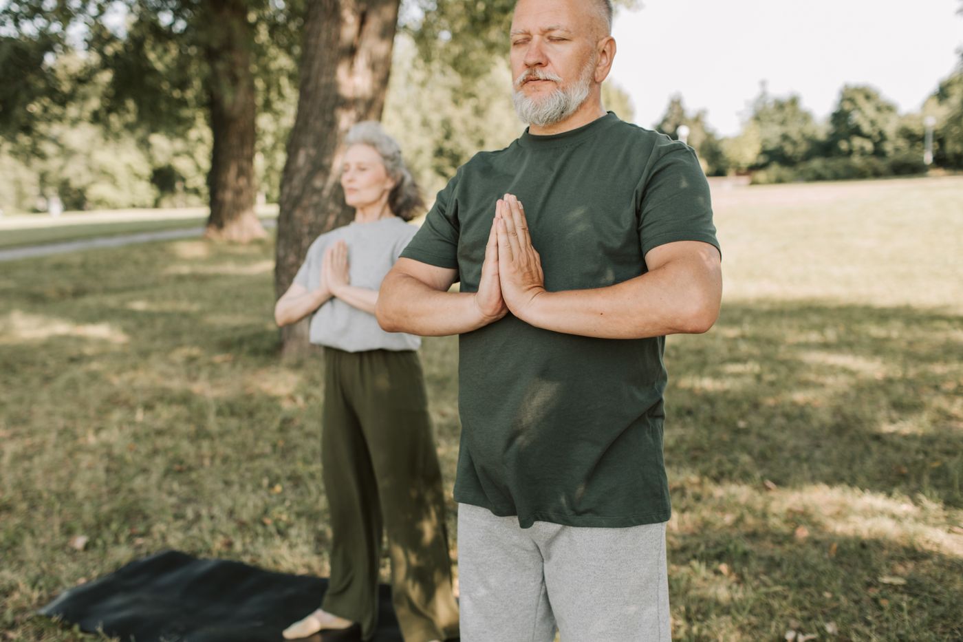 Senior couple practicing yoga outdoors for joint and bone health